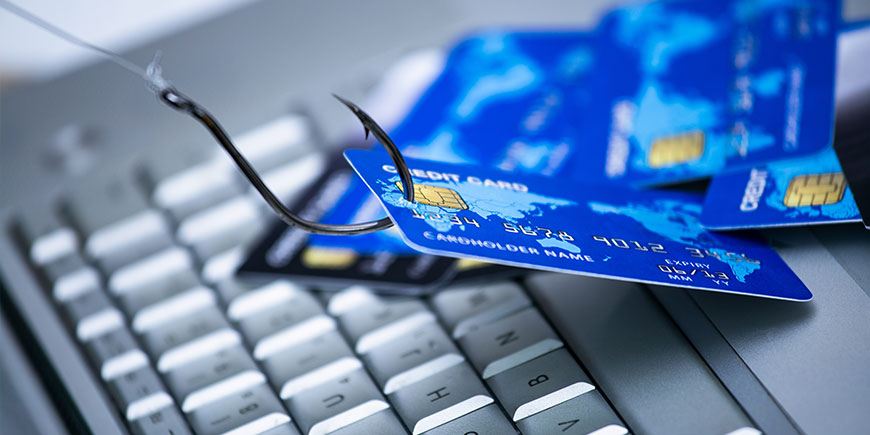 Credit card phishing. Piles of credit cards with a fish hook on computer keyboard. Credit card phishing scam with credit card in fishing hook Di Graphicroyalty